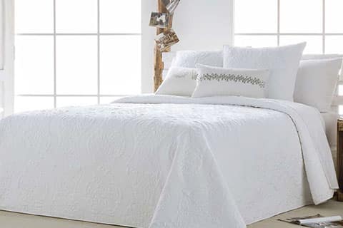 Ropa de cama de matrimonio en color blanco con cojines decorativos